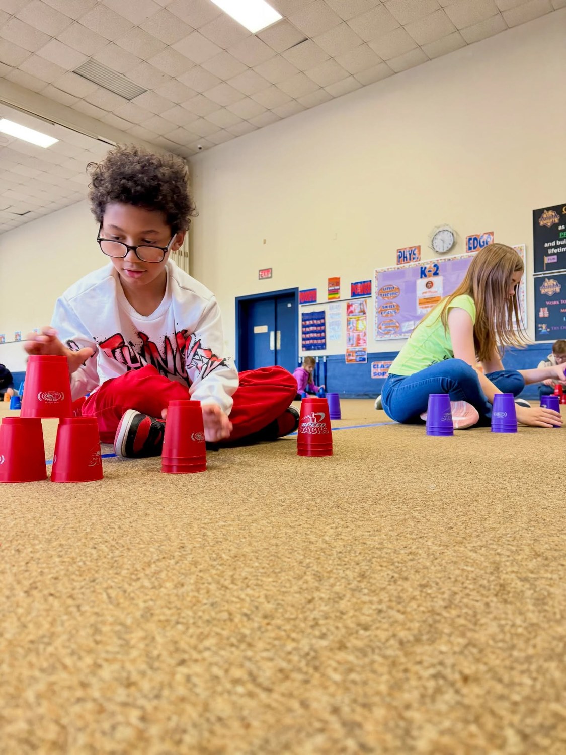 A student concentrates while building a sport-stacking pattern